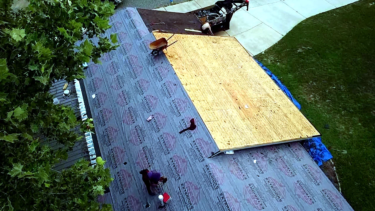 Crew replacing damaged roof decking with new plywood