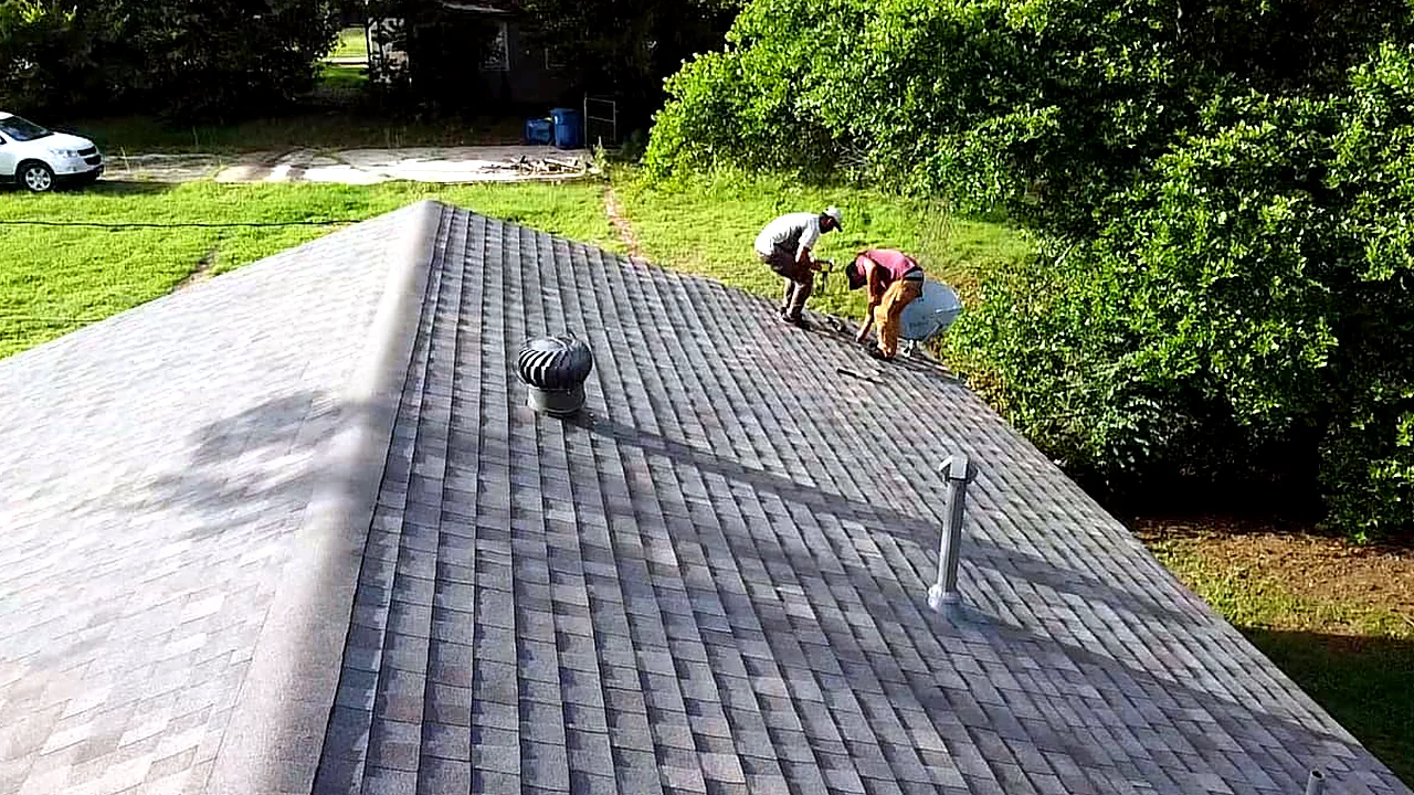 Crew finishing a shingle roof replacement.